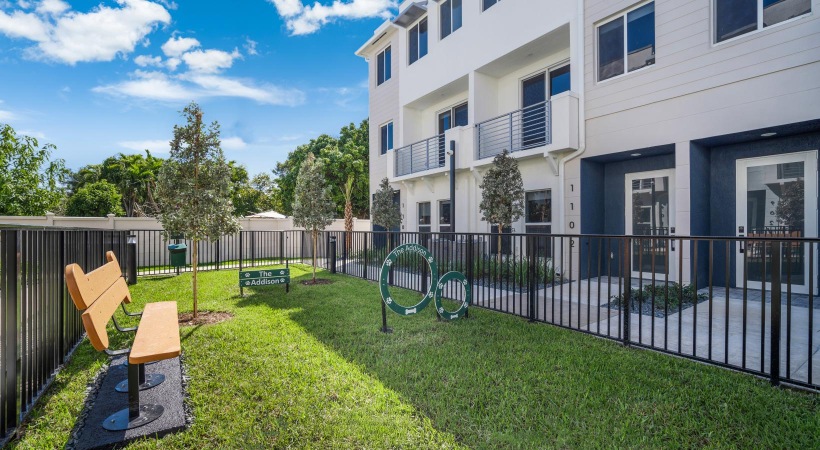 a backyard with a bench and a fence and a building